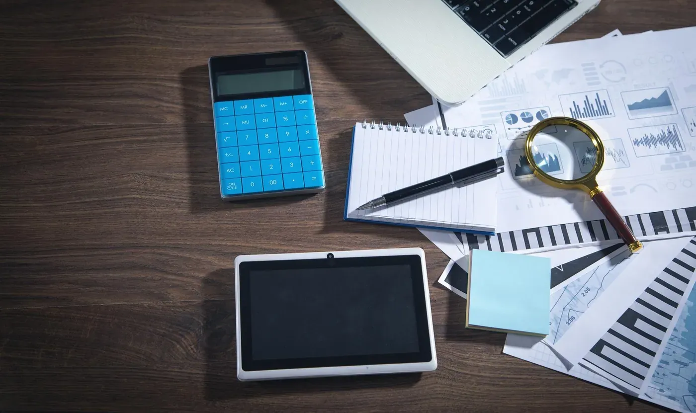Análisis contable: gráficos financieros, calculadora y documentos sobre el escritorio