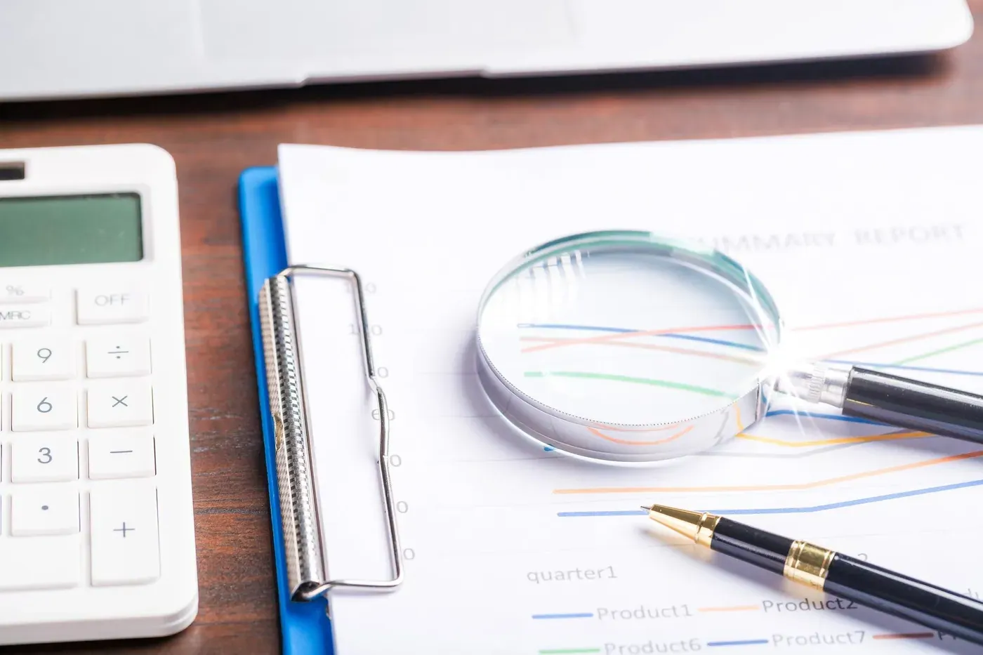 Auditoría: lupa, reporte financiero y calculadora sobre el escritorio